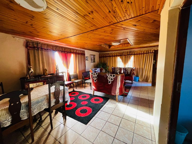 Open plan living and dining area featuring a timber tongue and groove ceiling and ceramic tiled flooring.
