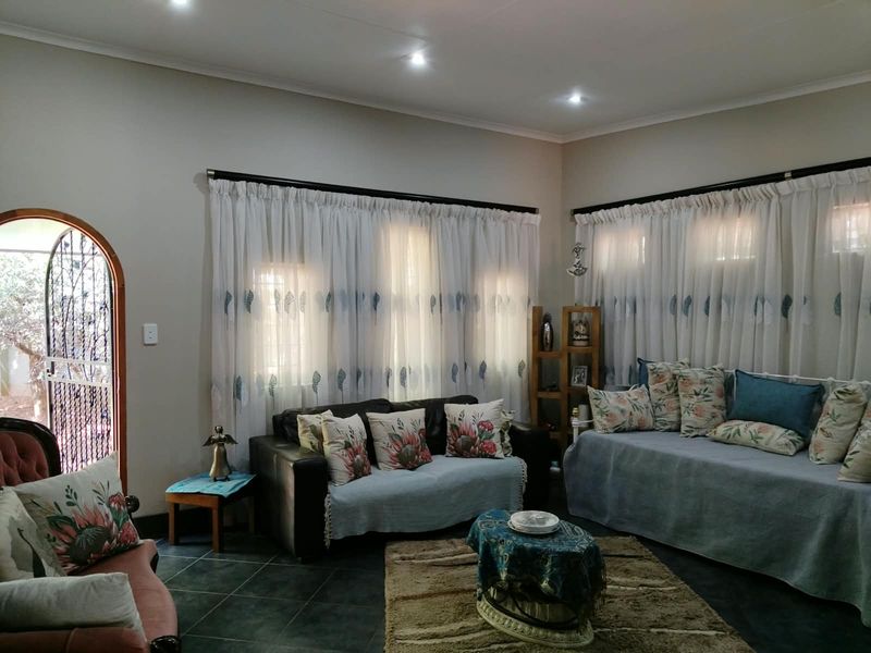 A comfortable living room featuring tiled flooring, recessed downlighting, and an arched doorway leading to the exterior.