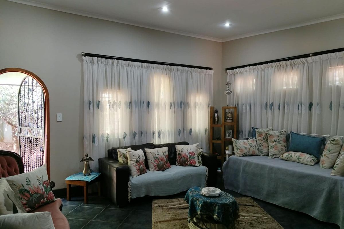 A comfortable living room featuring tiled flooring, recessed downlighting, and an arched doorway leading to the exterior.