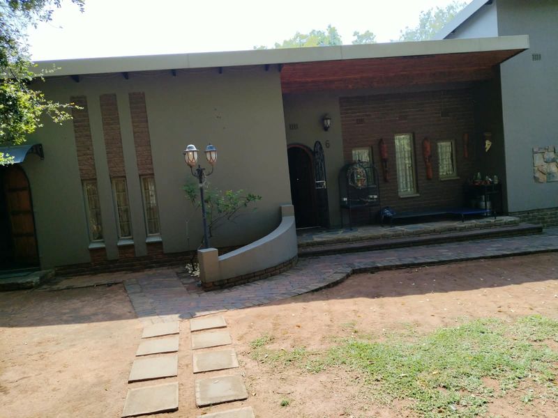 Front elevation of the house featuring a covered entrance porch, brick detailing, and a paved walkway leading to the main door.