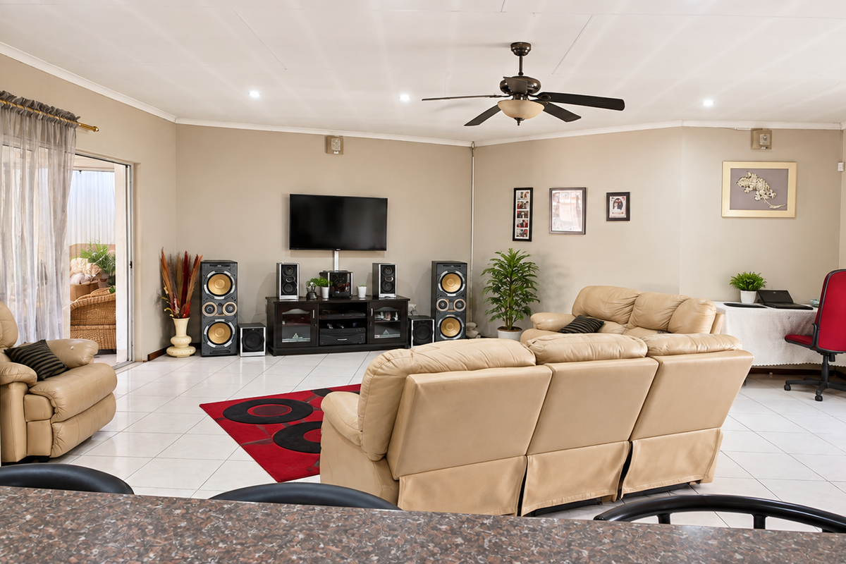 Spacious living room featuring tiled flooring, a ceiling fan, and sliding glass doors leading to an outdoor area.