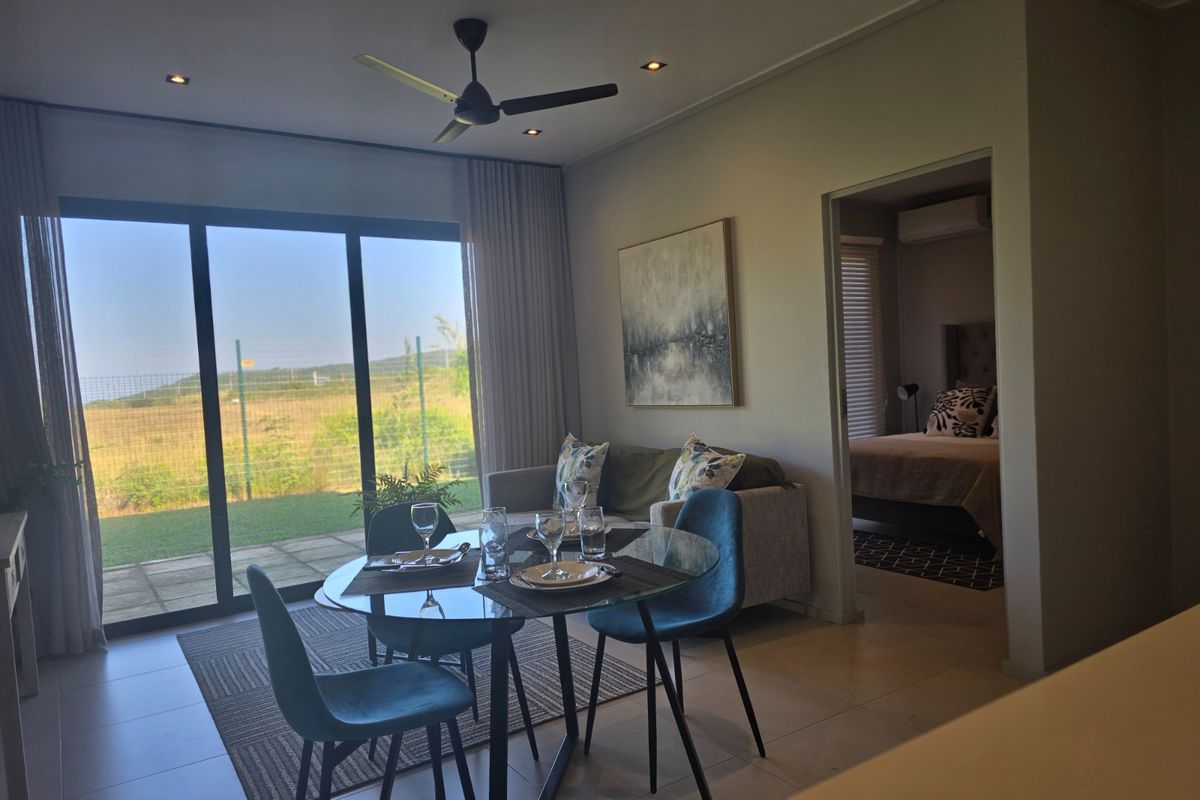 Open plan living and dining area featuring tiled floors, recessed lighting, and large sliding glass doors leading to an outdoor patio area.
