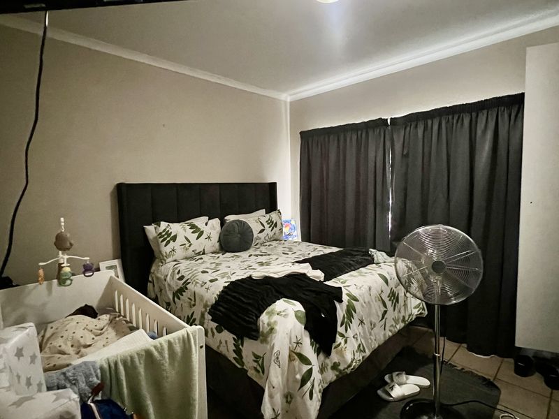 A standard bedroom featuring neutral walls, coving, and a built-in wardrobe, providing a functional space for rest.