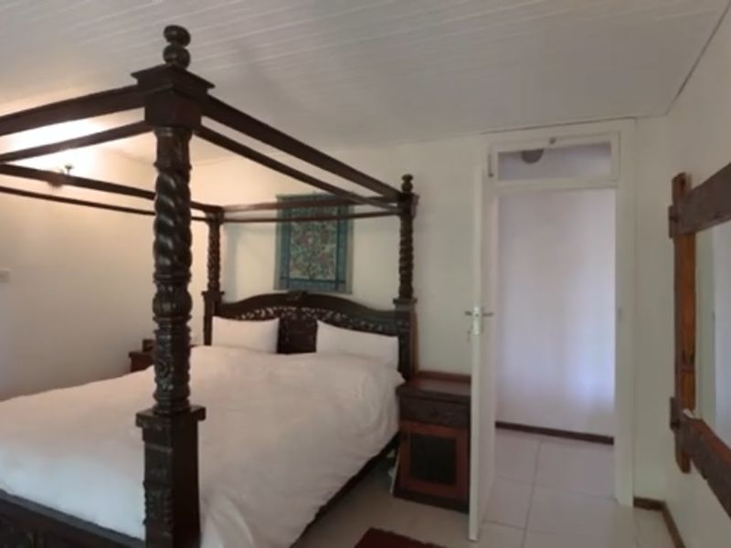 A bedroom featuring tiled flooring and a timber ceiling, with an internal door leading to an adjacent space.