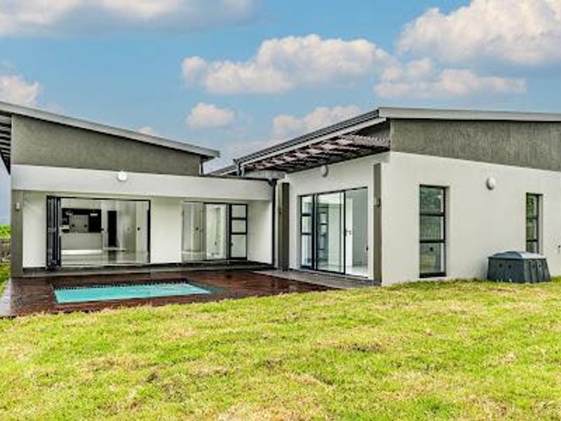 Modern rear elevation featuring a swimming pool, timber decking, and large glass sliding and bi-fold doors connecting the interior to the outdoor space.