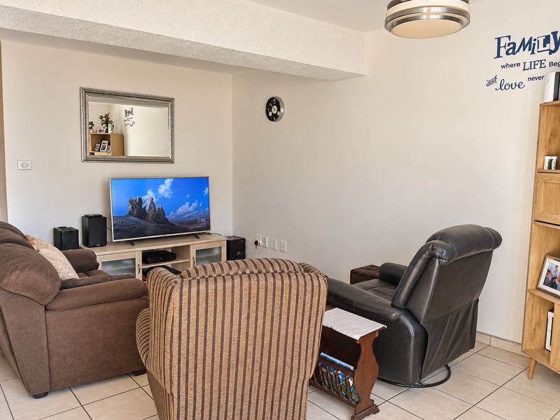 A comfortable living room area featuring tiled flooring and neutral wall finishes, providing a functional space for relaxation.