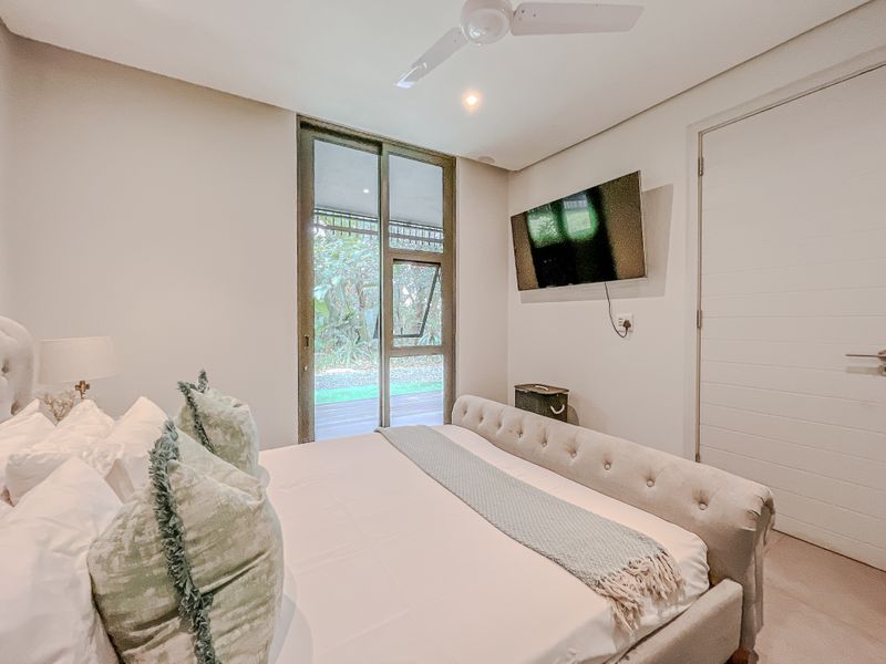 A well-maintained bedroom featuring a ceiling fan, recessed lighting, and a sliding glass door providing access to an outdoor area.