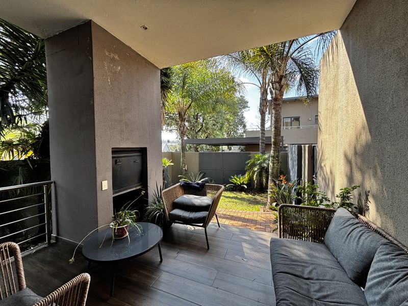 Covered patio featuring a built-in braai, tiled flooring, and direct access to a private garden area.