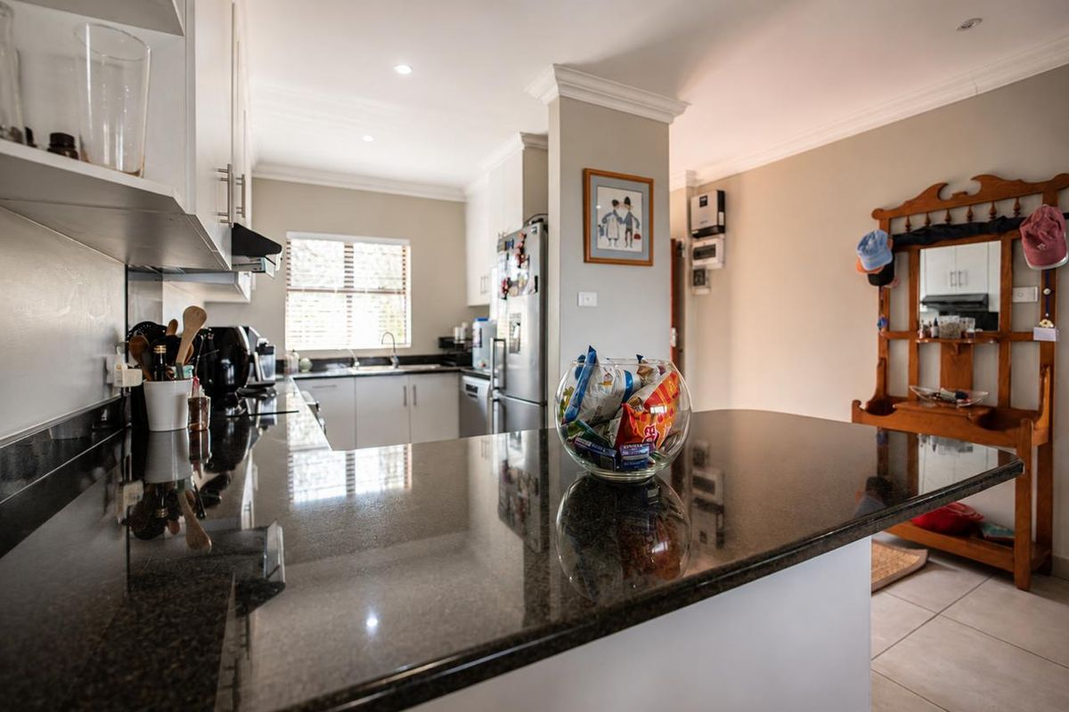A well-maintained kitchen featuring dark granite countertops, white cabinetry, and tiled flooring, offering a clean and functional workspace.