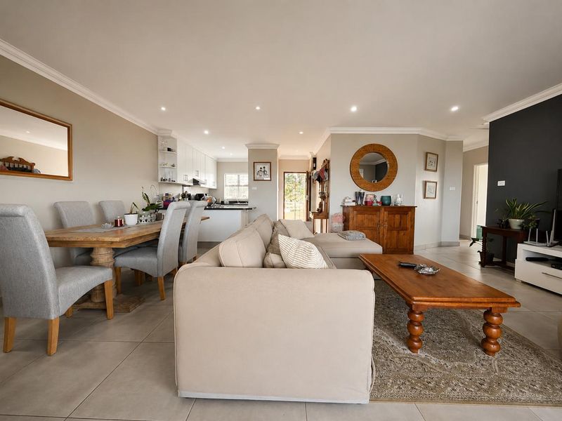 Spacious open-plan living and dining area featuring tiled floors, recessed lighting, and a modern kitchen with integrated cabinetry.