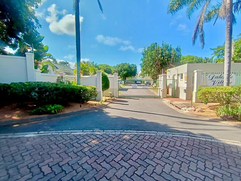 The entrance to Dale Village features a secure gated access point with paved driveway and established perimeter landscaping.