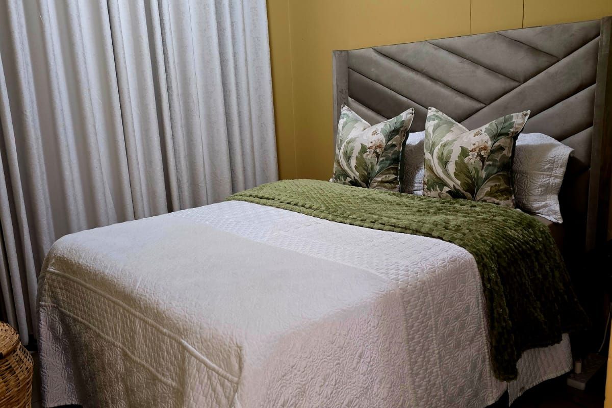 A cozy bedroom featuring tiled flooring and crown molding, providing a neutral foundation for personalization.