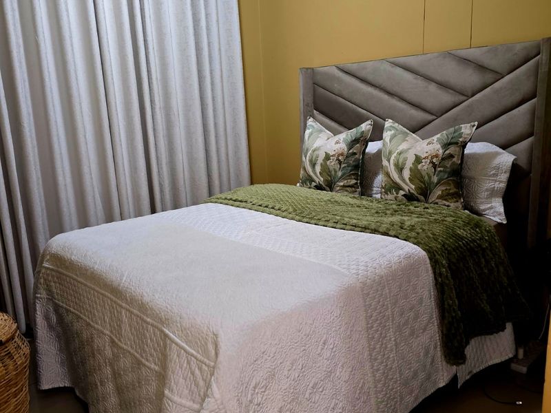A cozy bedroom featuring tiled flooring and crown molding, providing a neutral foundation for personalization.