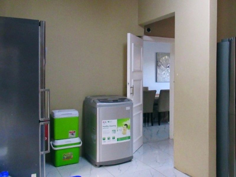 A functional laundry area featuring tiled flooring and direct access to adjacent living spaces.