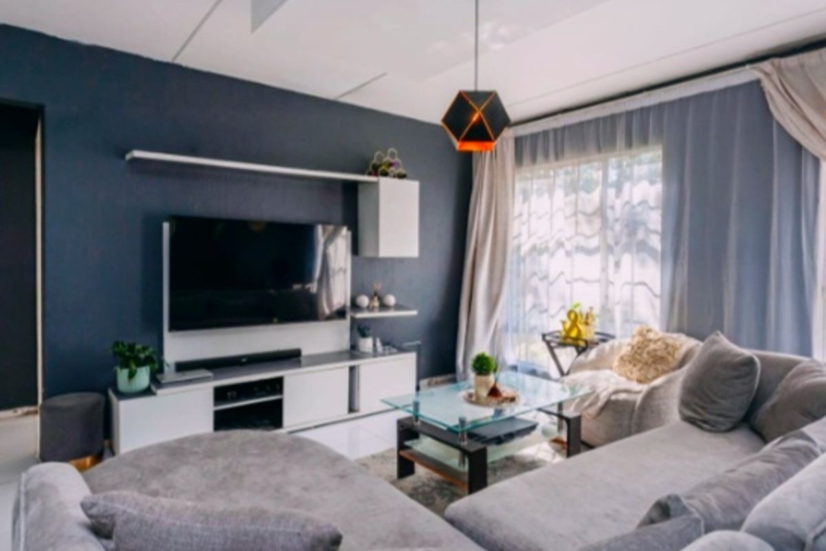 A well-maintained living room featuring a built-in media console, floating shelving, and modern pendant lighting, creating a comfortable and functional living space.
