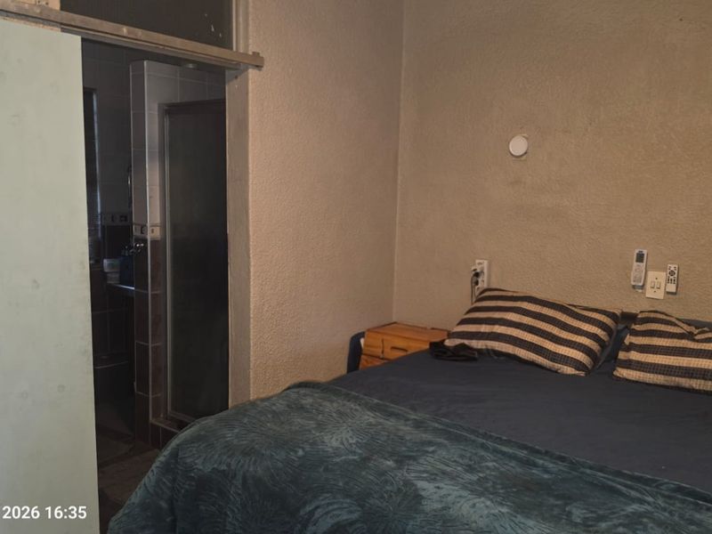 A bedroom featuring textured walls and a sliding door leading to an adjacent bathroom area.