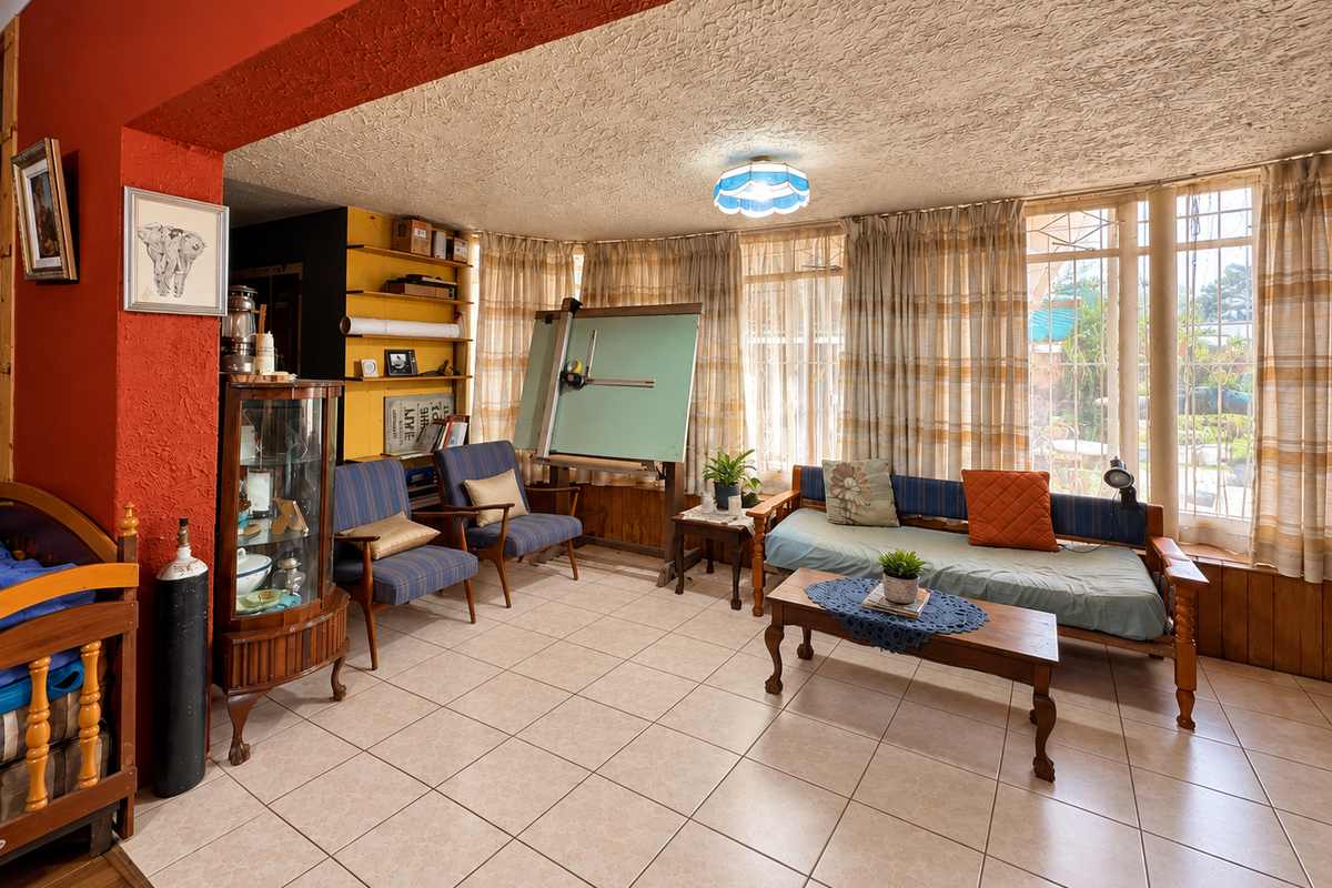 A living area featuring tiled flooring, textured ceilings, and built-in shelving, with large windows providing natural light.