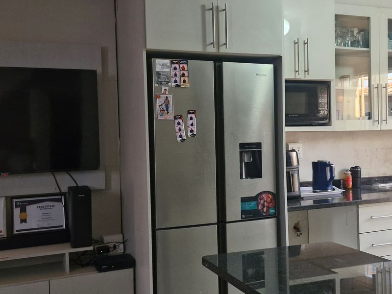 Open-plan living and kitchen area featuring modern cabinetry, granite countertops, and a functional layout with integrated appliances.