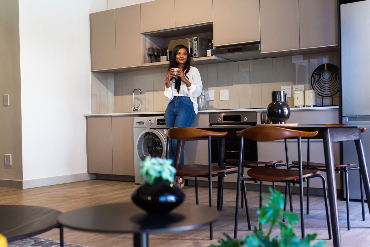 Modern open-plan kitchen featuring sleek cabinetry, integrated appliances, and high-quality finishes, seamlessly flowing into the living area.