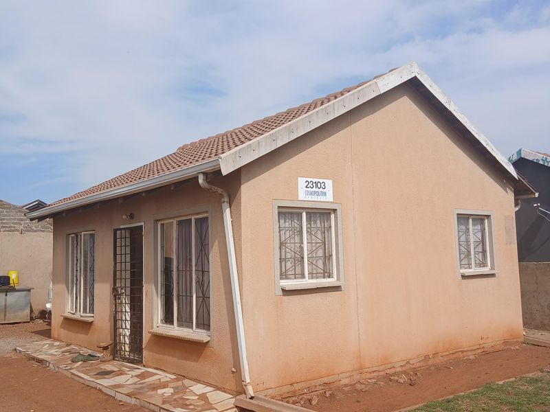 A detached single-story house featuring a tiled roof, security bars on windows, and a security gate at the entrance.