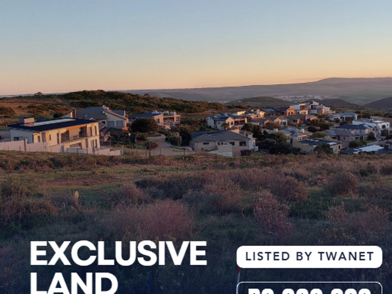 A scenic landscape view overlooking a residential estate at sunset, showcasing the surrounding natural terrain and neighborhood development.