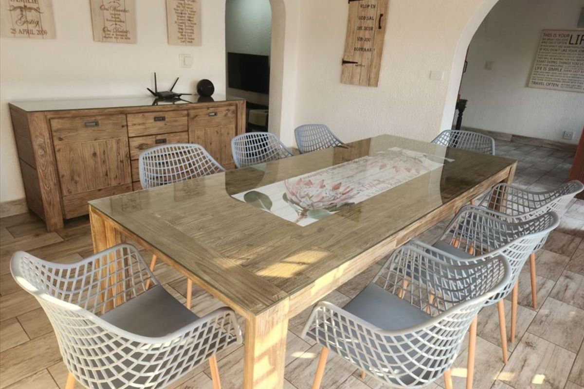 A bright dining area featuring tiled flooring and distinctive arched doorways leading to adjacent living spaces.