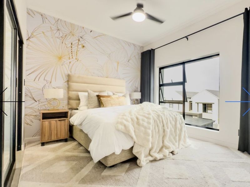 A well-lit bedroom featuring a modern ceiling fan, large aluminium-framed windows, and decorative feature wallpaper.