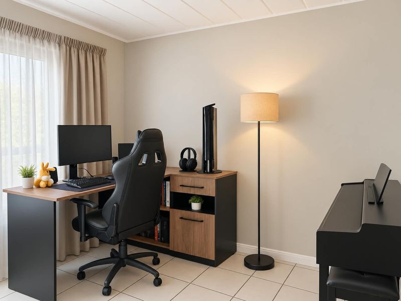 A well-lit home office space featuring neutral wall tones, tiled flooring, and large windows with curtains, providing a functional and comfortable workspace.