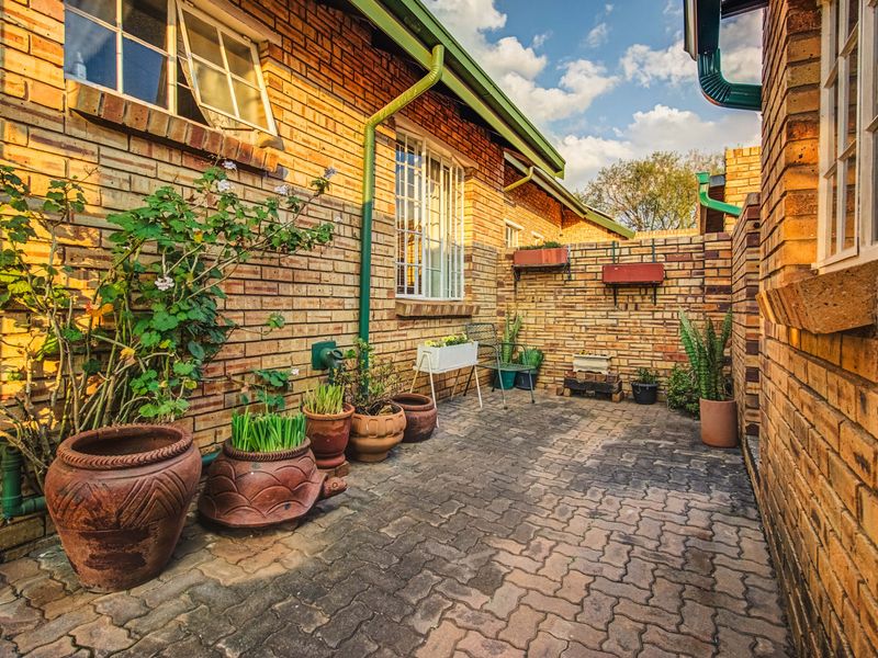 A private rear courtyard featuring durable facebrick walls, brick paving, and functional guttering systems, providing a low-maintenance outdoor space.