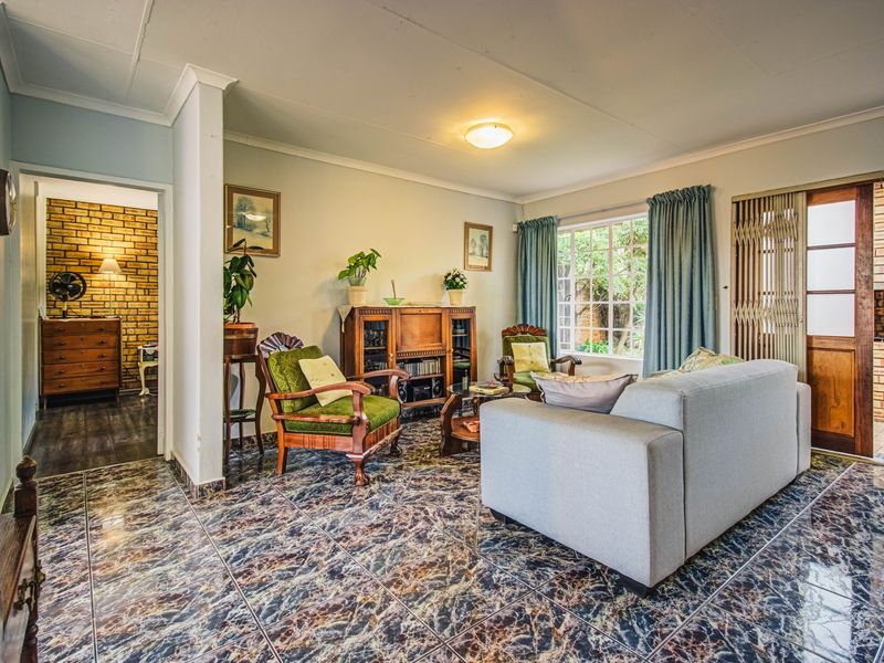 A living room featuring tiled flooring, coving, and a sliding door providing access to an outdoor area.