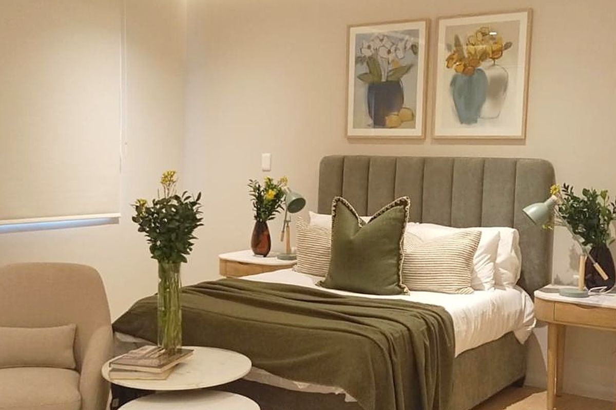 A well-maintained bedroom featuring neutral wall tones and a functional roller blind for privacy.