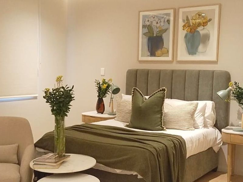 A well-maintained bedroom featuring neutral wall tones and a functional roller blind for privacy.