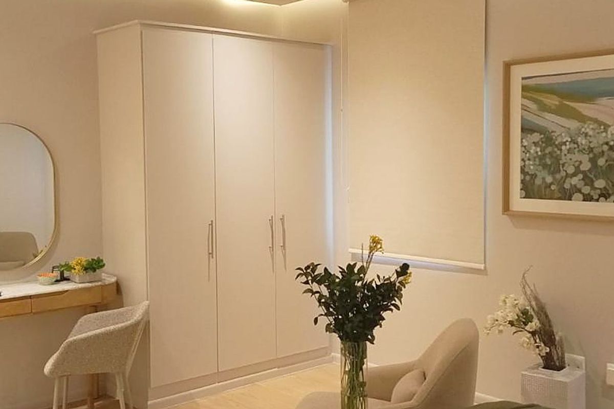 A well-maintained bedroom featuring a neutral color palette, built-in wardrobe storage, and recessed ceiling lighting.