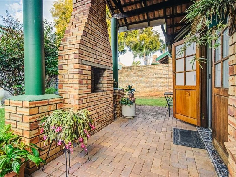 A covered patio area featuring brick paving and a built-in brick braai, providing a functional outdoor entertainment space.