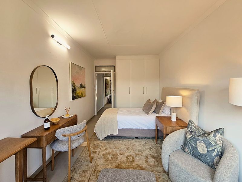 A well-maintained bedroom featuring built-in cupboards and neutral finishes, providing a comfortable and functional living space.