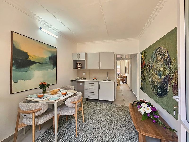 A compact kitchen area featuring built-in cabinetry, a stainless steel sink, and tiled flooring, providing a functional space within the retirement unit.