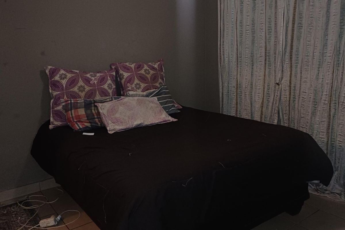 A bedroom featuring tiled flooring and wall-mounted curtain tracks, currently requiring cosmetic updates to improve the overall finish and lighting.