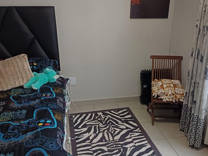 A bedroom featuring tiled flooring and a neutral wall finish, providing a functional space for rest.