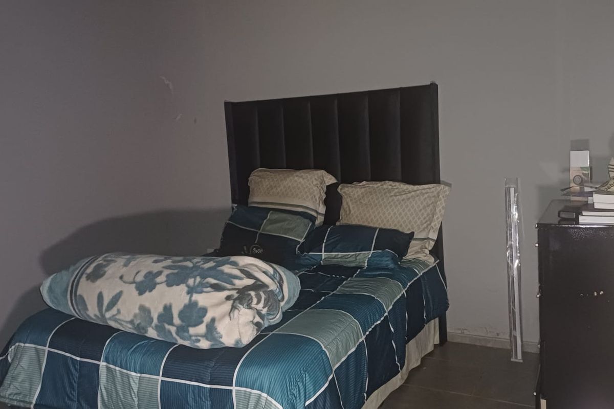A bedroom featuring tiled flooring and plain walls, currently requiring cosmetic updates to improve the overall aesthetic and finish.