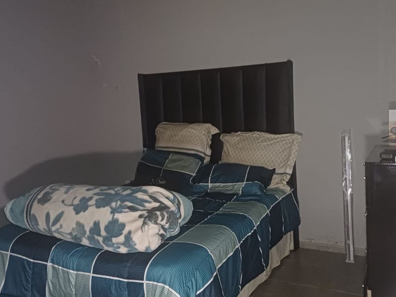 A bedroom featuring tiled flooring and plain walls, currently requiring cosmetic updates to improve the overall aesthetic and finish.