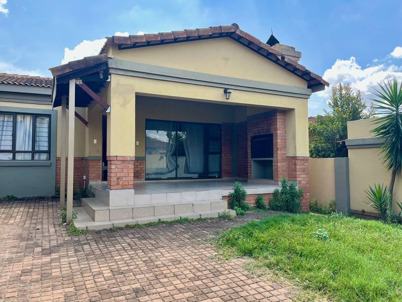 Covered patio area featuring a built-in braai, tiled flooring, and direct access to the interior through sliding glass doors.