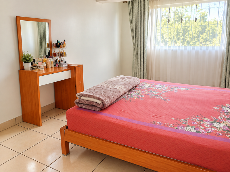 A well-lit bedroom featuring neutral tiled flooring, large windows with security bars, and neutral wall finishes, providing a functional and comfortable living space.