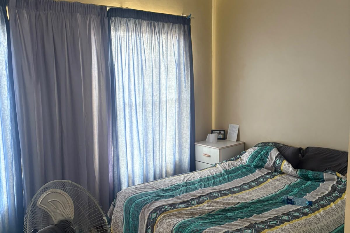 A functional bedroom featuring a ceiling fan and laminate flooring, providing a comfortable and practical living space.