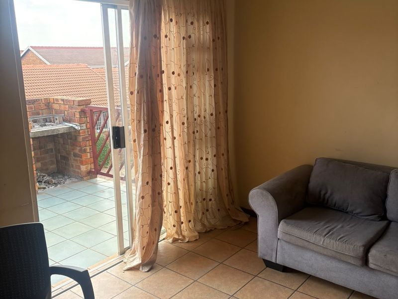 Living area featuring ceramic tiled flooring and a sliding glass door providing direct access to an outdoor patio space.