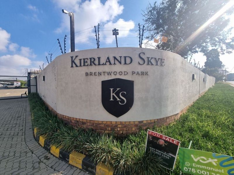 Exterior view of the Kierland Skye complex entrance, featuring a prominent boundary wall with security fencing and signage.