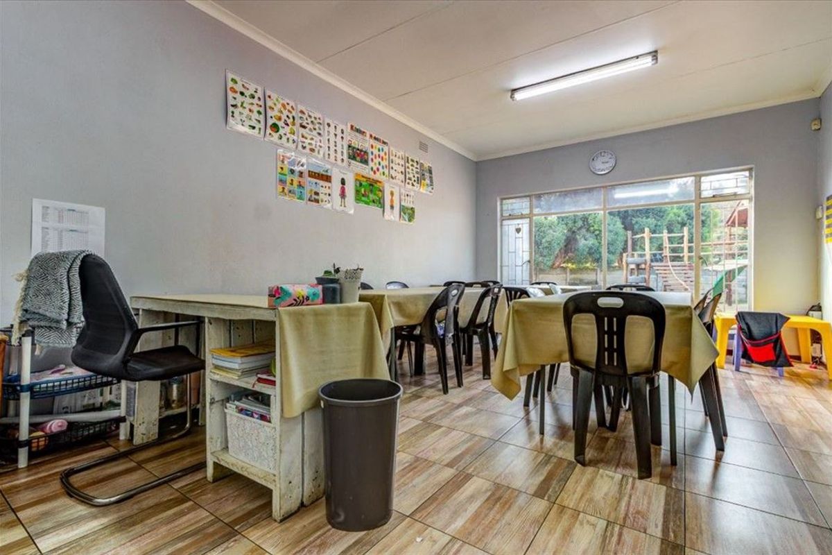 A multi-purpose room featuring tiled flooring and a large glass sliding door providing natural light and access to the outdoor area.
