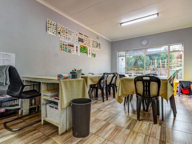 A multi-purpose room featuring tiled flooring and a large glass sliding door providing natural light and access to the outdoor area.