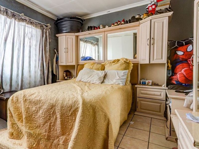 Bedroom featuring built-in cabinetry and tiled flooring, offering potential for modernization and aesthetic improvement.