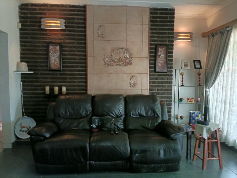 Living room featuring an exposed brick accent wall with decorative central tiling and wall-mounted lighting.