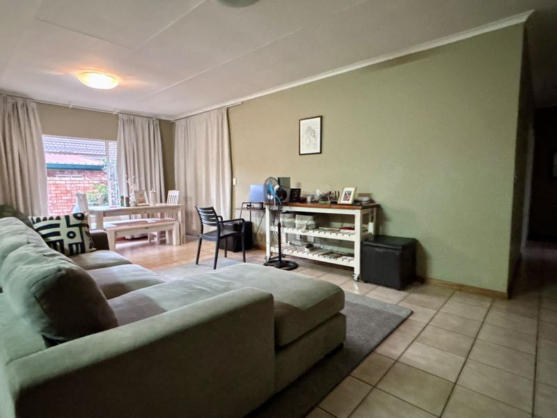A spacious living area featuring neutral wall tones and tiled flooring, offering a comfortable and functional layout for daily living.